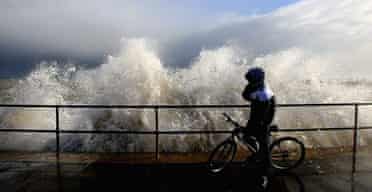 A cyclist is caught out by a huge wave in Great Yarmouth