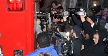 Photographers try to get a shot through the back window of a Los Angeles City Fire Department ambulance, believed to carrying entertainer Britney Spears, as it leaves her residenceJanuary 3 2008, in Los Angeles. 