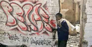 A boy walks past street graffiti in Nairobi, Kenya
