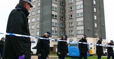 Police officers search the area in front of Verona House in Erith, where a teenage boy was stabbed to death 