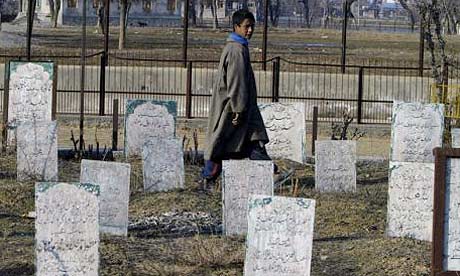 A Kashmiri boy walks in a graveyard in Srinagar, India