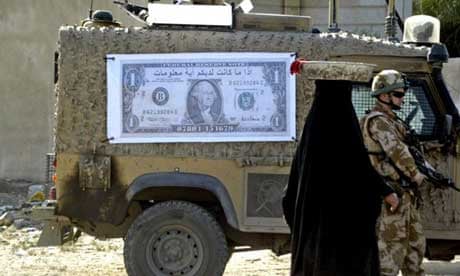An Iraqi woman walks past a British soldier and military vehicle with a poster of a dollar bill with the Arabic writing: You can get some money, in exchange for some information". Photograph: Essam al-Sudani/AFP/Getty Images