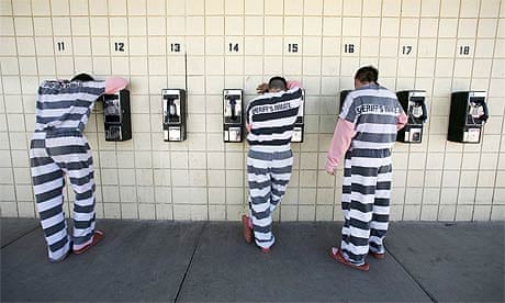 Inmates talk on pay phones at a jail in Phoenix, Arizona