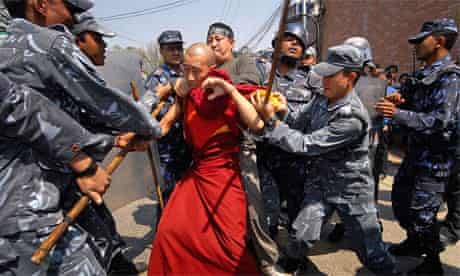 Nepalese policemen arrest a Tibetan monk during a demonstration in front of the Chinese embassy in Kathmandu