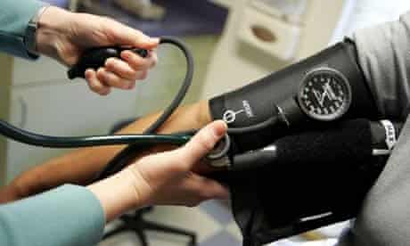 A doctor reads a blood pressure gauge during an examination of a patient. Photograph: Joe Raedle/Getty Images