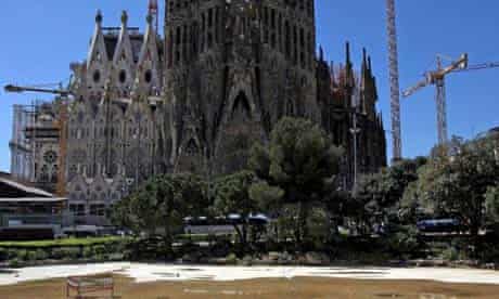 A tourist walks through what is barely a puddle in the Sagrada Familia Lake