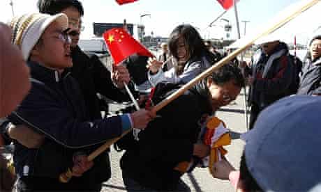 A man carrying a Tibetan flag is attacked by pro-China supporters awaiting the start of the Olympic torch relay in San Francisco