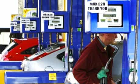 A man is warned by a sign not to pump more than £20 worth of petrol at a garage forecourt in Linlithgow, Scotland