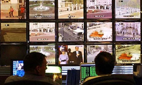 Police officers monitor CCTV screens in the control room at New Scotland Yard in London