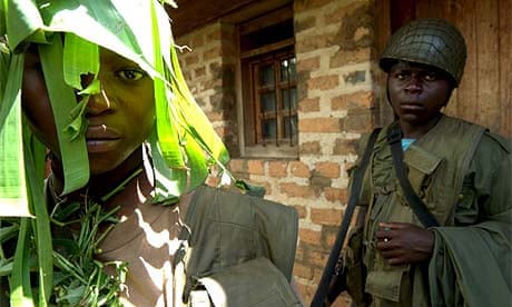 Child soldiers from the Mai-Mai militia guard the headquarters of their leader in Kisharu, Democratic Republic of Congo
