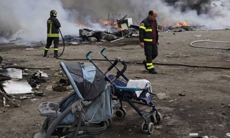 Firefighters inspect the remains of a Gypsy camp set alight in Naples