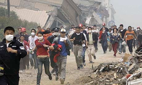 Residents and rescue workers evacuate from the centre of Beichuan county, China