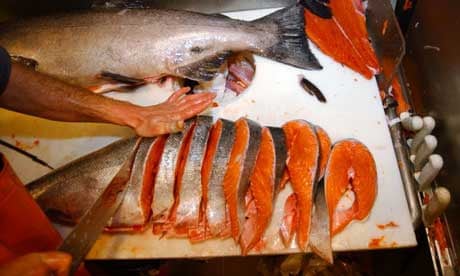 A salmon is cut into steaks at the Pike Place fish market in Seattle. Photograph: Elaine Thompson/AP