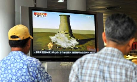 South Koreans at a railway station in Seoul watch a video showing a simulation of the planned blow-up of a cooling nuclear tower at North Korea's Yongbyon nuclear complex