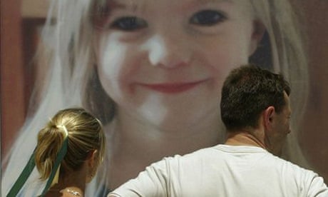 Parents of missing child Madeleine McCann, Kate and Gerry McCann look at a giant billboard of her daughter on the beach near the Portuguese resort of Lagos