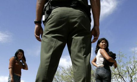 A border patrolman looks on as two Mexican women are caught trying to cross into the US