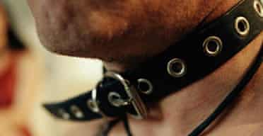 Man wearing leather collar and harness