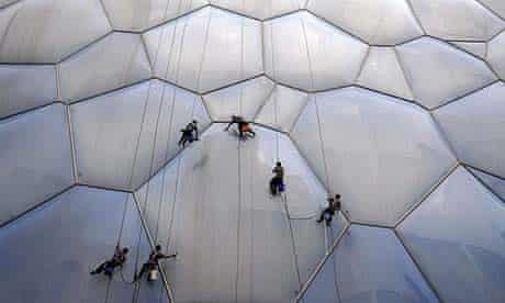 Workers clean the bubble-shaped surface of the National Aquatics Centre in Beijing in preparation for next months Olympics