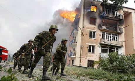 Georgian soldiers run past a building hit by bombardment in Gori, 50 miles from Tbilisi, Georgia
