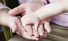 A baby holding her mother's hand