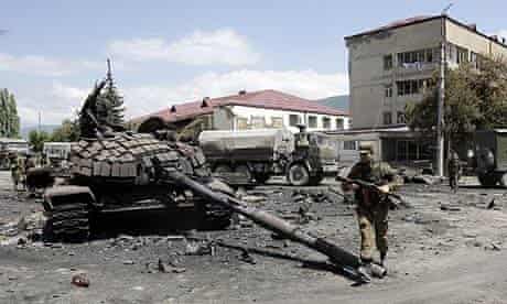 A Russian soldier walks past destroyed Georgian tanks in the South Ossetian capital of Tskhinvali