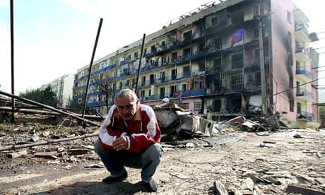 A Georgian man squats amid the rubble of a destroyed street in the town of Gori, Georgia