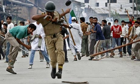 An Indian policeman is hit by an object thrown by a Kashmiri protester in Srinagar 