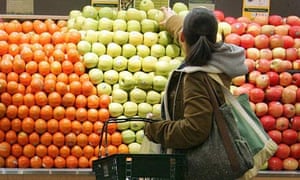 A woman selects apples while shopping in the produce section at Whole Foods in New York
