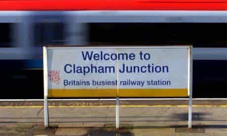  A commuter train passing the sign at Clapham Junction railway station in London