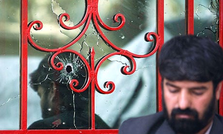 A window at the Kabul offices of the courier company DHL bears the scars of a shootout in which at least three people were killed