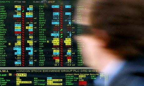 A worker walks past a screen displaying stock market movements at a window of the London Stock Exchange in the City of London, October 27, 2008