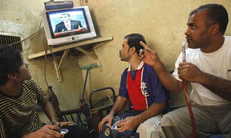 Iraqi men watch a repeat of the last US presidential debate at a coffee shop in Baghdad