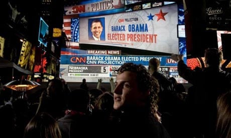 Barack Obama is show on a giant screen at an election night party in Times Square