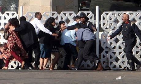 People take cover at the Taj Mahal hotel in Mumbai