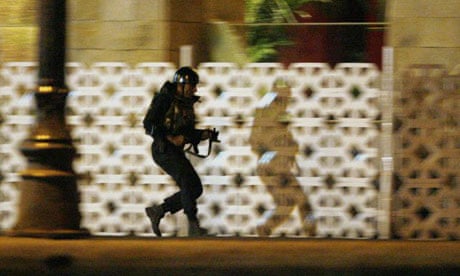 A commando takes up position during an ongoing gun battle at the Taj hotel in Mumbai