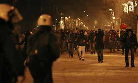 Protesters walk towards policemen during riots in Athens