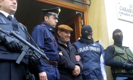 Italian police escort mafia suspect Giuseppe Scaduto (centre) from their headquarters in Palermo.