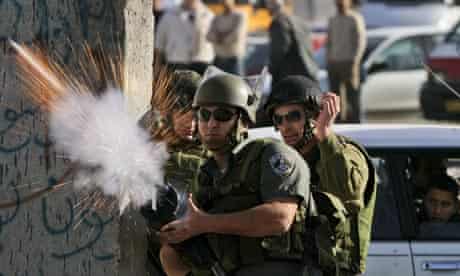 Israeli border police officer fires a tear gas canister