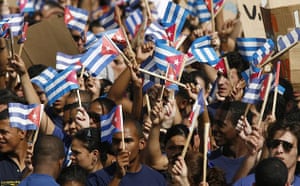 Young Cubans wave flags during a May Day parade on Havana's Revolution Square 