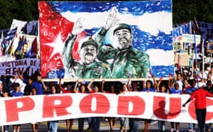 Cubans march holding a banner during the annual May Day parade at the Revolution Square in Havana, Cuba