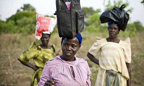 Alice Adebo and her friends carry bags on their heads in Amorikot, Katine