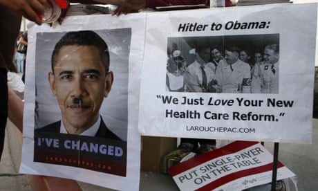 Posters comparing Barack Obama to Adolf Hitler are taped to a table at a town hall meeting on healthcare in Alhambra, California.