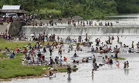 Earthquake survivors gather at a river as their main source of water in Padang, Indonesia