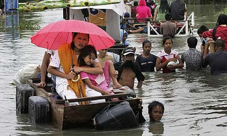 A woman and young girl ride through floodwaters in Rizal province, east of Manila