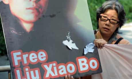 A protestor holding a picture of Chinese writer Liu Xiaobo marches to the US consulate in Hong Kong
