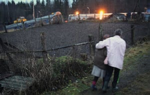 Russia Train Crash: Local villagers pass by a damaged railway carriages 