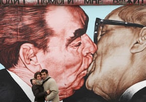 Berlin Wall: A tourist couple from Italy pose in front of the Brotherkiss mural