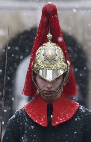 December snow: A member of the Household Cavalry stands guard during a snow shower