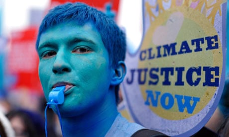A climate change demonstrator with his face painted blue protests in London.