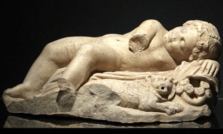 A marble statuette of a sleeping Eros and a lion next to him